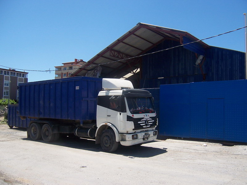 Açık kasa konteyner yüklü toplama aracı, tesis önünde
